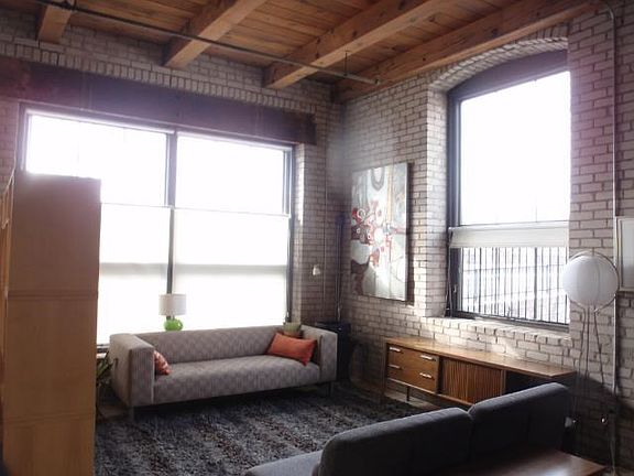 NATURAL SOPHISTICATION Open living area with massive Douglas Fir beamed ceilings,exposed brick walls,rich hardwood floors,flooded in natural light!