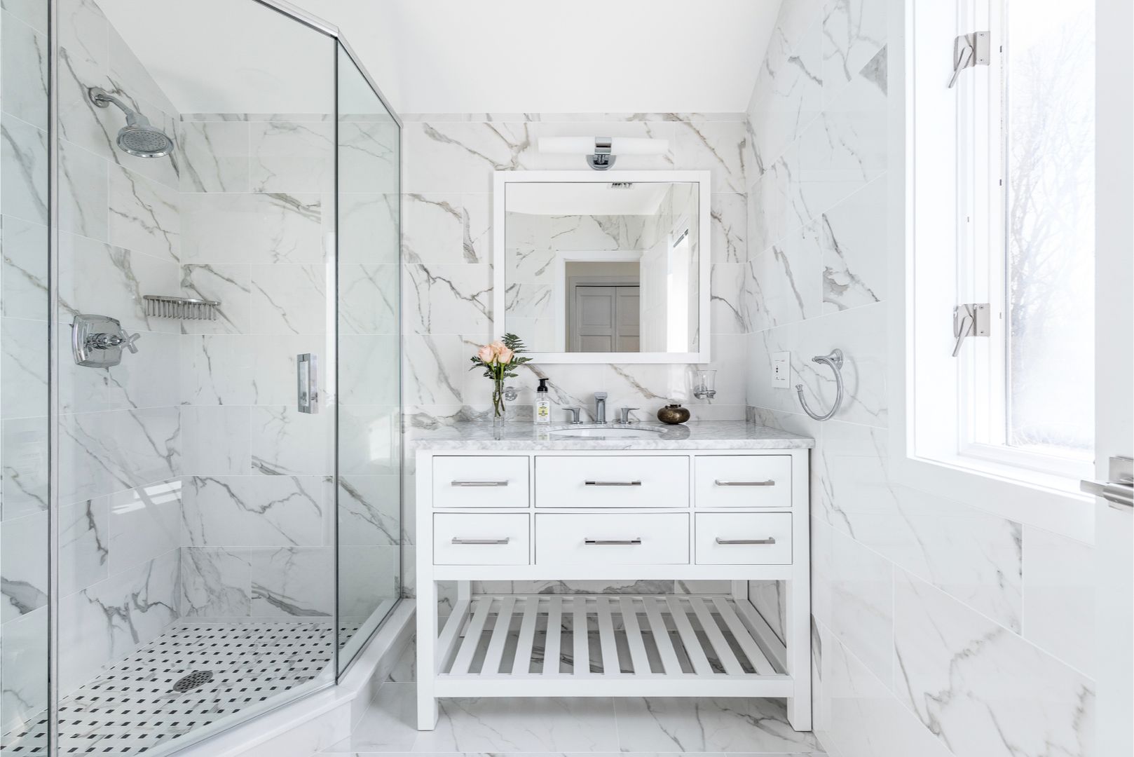  En-suite guest bathroom features marble interiors. Walk-in rain shower and vanity sink.
