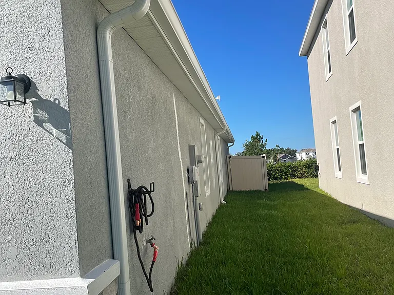 side of the house with gutter and fence