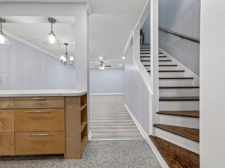 View from front door toward kitchen, staircase to 2nd floor and dining/living area.