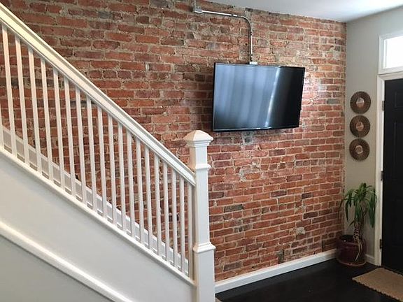 Exposed 100 year old brick adds loads of charm. Wall mounted TV with "exposed" wiring gives an industrial feel.