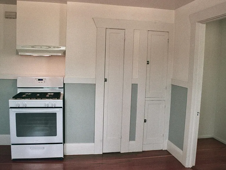 Original cabinetry, gas stove, and new vented hood.