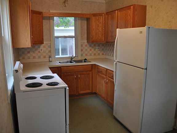 Kitchen with stove, fridge, and garbage disposal