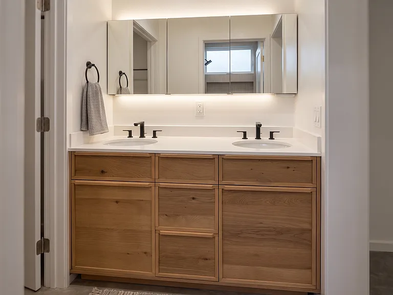 Primary bath has a stained vanity with dual sinks