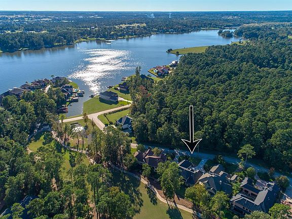 Nestled against mature trees with detailed landscaping, notice the undeveloped acreage across this home for added privacy.