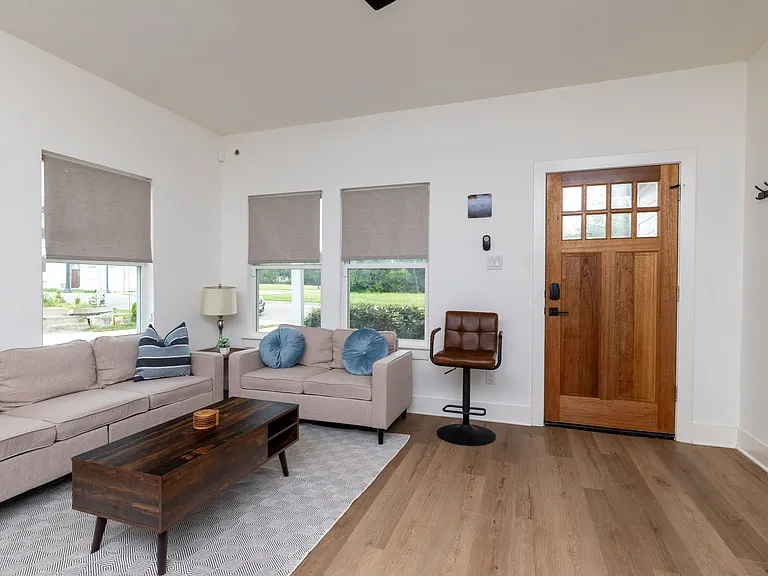 Relax in this bright, open-concept living room featuring a spacious L-shaped sectional ideal for group lounging or family movie nights.