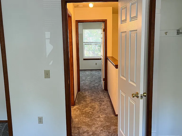 Hallway connecting two bedrooms on upstairs level
