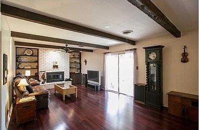 Large family room with beamed ceiling and exposed brick built-in