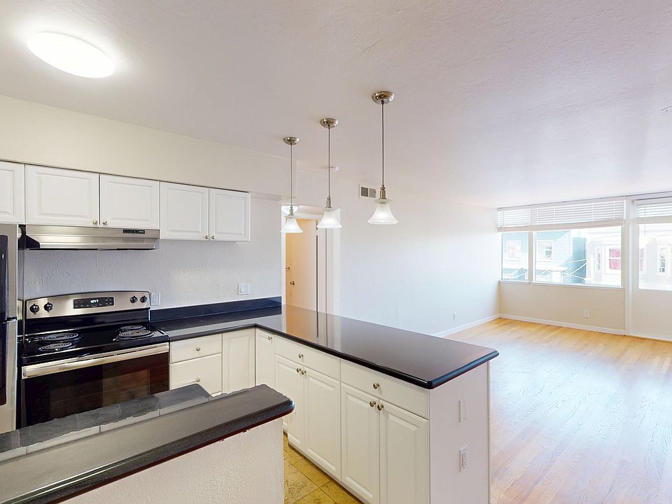 Kitchen with cabinets, refrigerator, stove, range hood, and sink