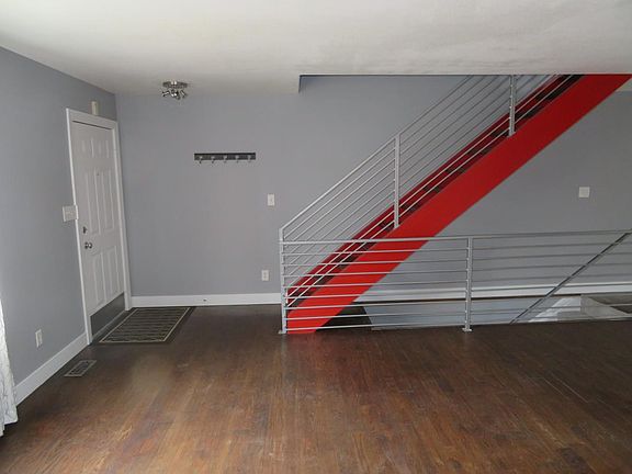 Dramatic red stairway with chrome railings at entry.