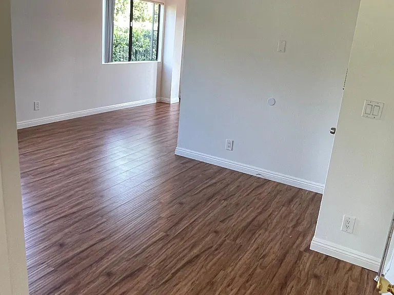 Entry into living room with dining area and kitchen to the right and bedroom and bath to the left of the bottom of the photo