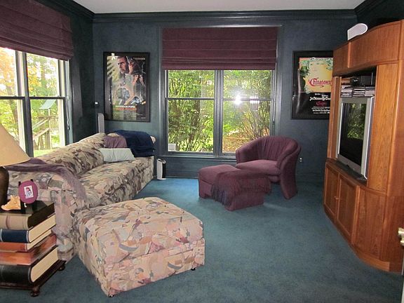 French doors lead to well appointed office/theater room w/ outside entry