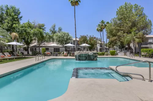 Dive into luxury at Boulders at Lookout Mountain's pool oasis, complete with a stunning fountain and palm tree backdrop - Boulders at Lookout Mountain Apartment Homes