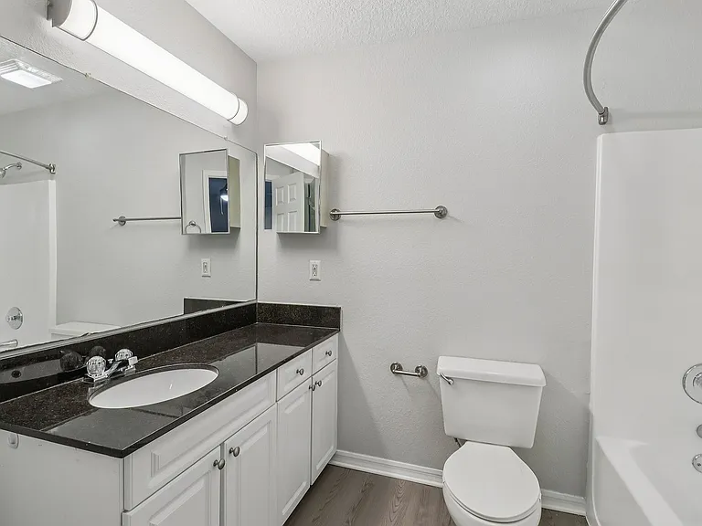Clean and functional bathroom with full-size tub and vanity