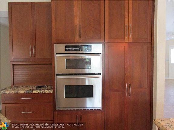 Double stainless steel ovens, pantry and ample storage. Note *storage garage door* to left of ovens