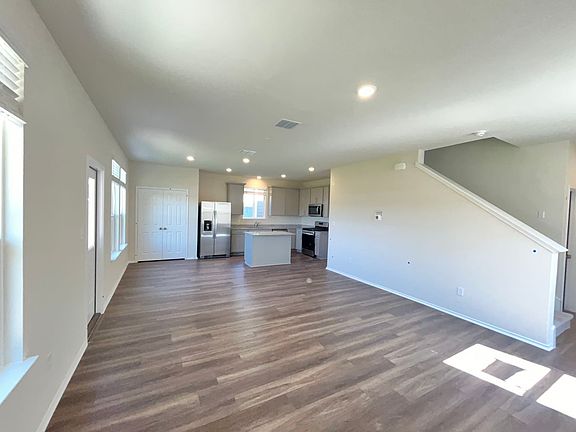 Bright, spacious open-concept living, dining, and kitchen area with new fridge included
