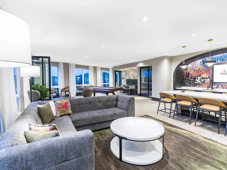 This expansive resident lounge offers plenty of space to gather, play, or unwind_with cozy seating, a pool table, and vibrant design accents throughout.