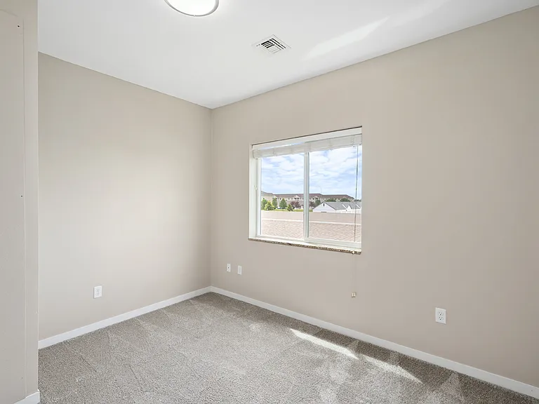 Bright and airy bedroom with large window, plush carpet, and neutral painted walls offering a peaceful retreat. Bright and airy bedroom with large window, plush carpet, and neutral painted walls offering a peaceful retreat.
