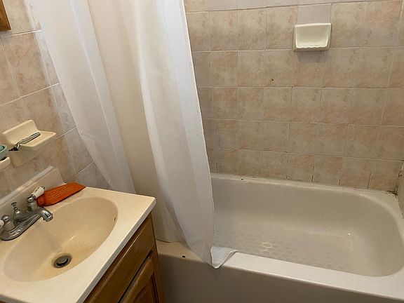 bathroom, one cabinet under the sink. one mirror with cabinet on top of the sink. Owner pays for water. one window beside the sink with blind.