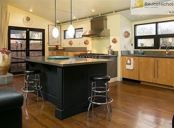 Stainless kitchen with vaulted ceiling and lots of windows.