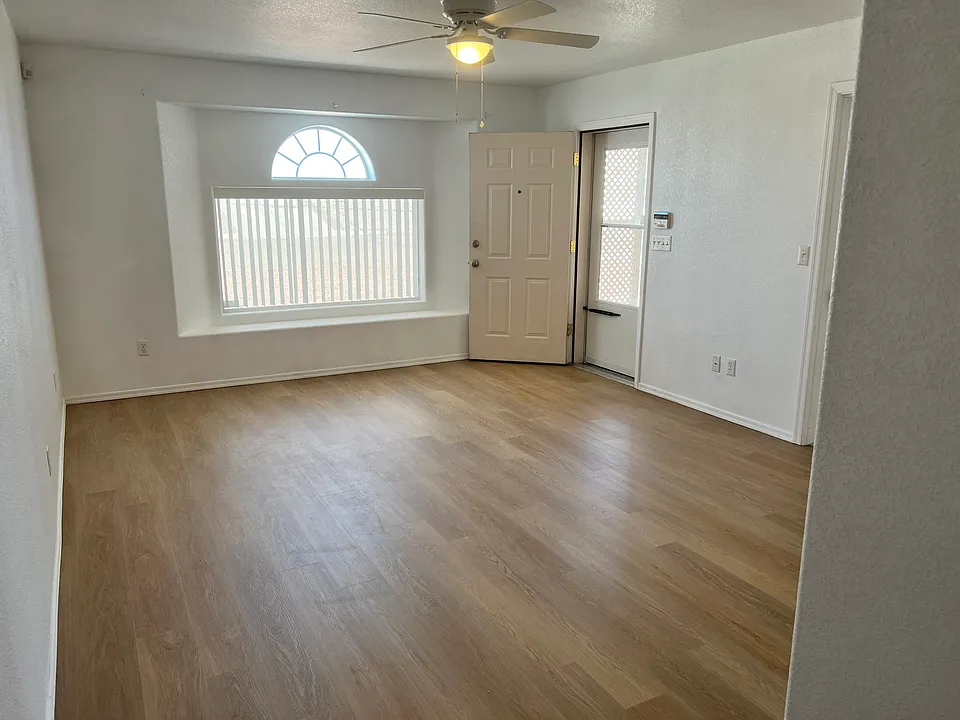 Living room and bay window facing the street. The window has a privacy screen that filters sunlight, allows a clear view out and no view in from the outside.