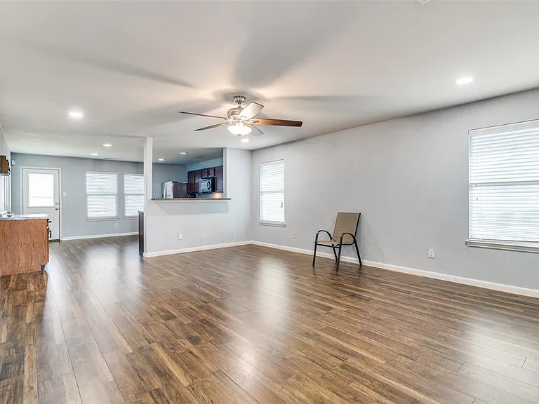Unfurnished living room with dark hardwood / wood-style flooring, a wealth of natural light, and ceiling fan