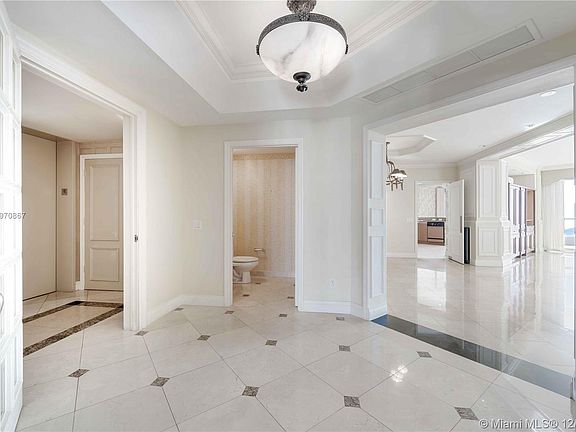 Entrance into condo with half bath on left and main living in front of you.  Walls have been digitally enhanced to white.  They 