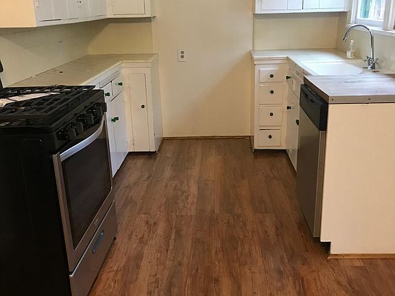 Kitchen with new Pergo flooring, gas stove and dishwasher