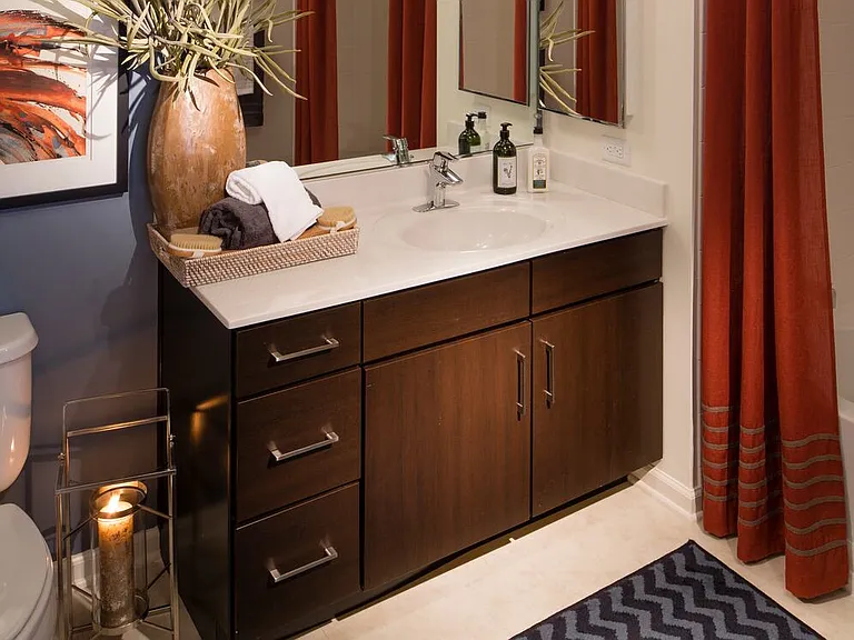 Bath with laminate countertop, espresso cabinetry, and tile flooring