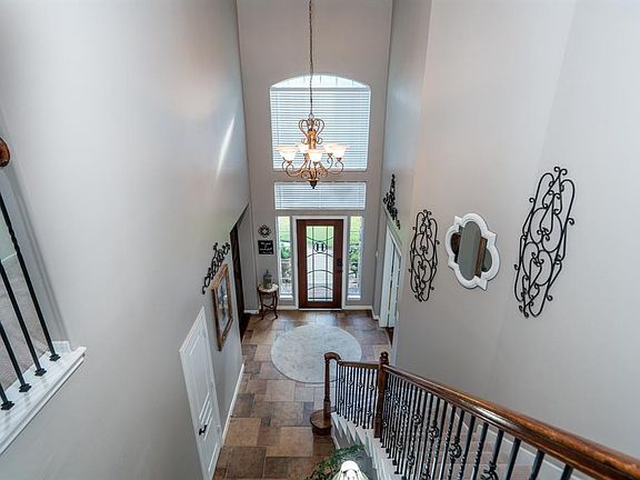 Soaring ceilings in the bright entry with tile floors. Notice the wrought iron balusters.
