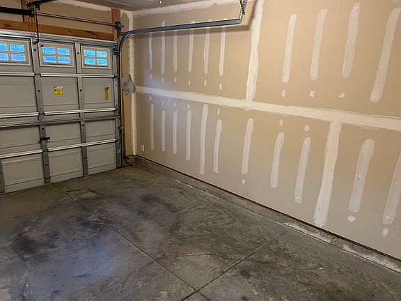 Finished garage with newly installed garage opener to park a car with plenty of additional storage space.