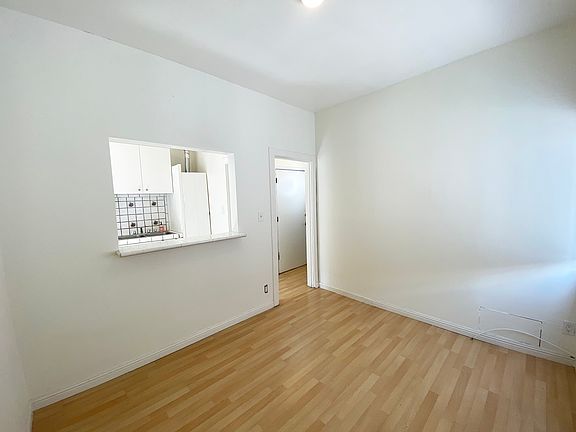 Living Room looking into Kitchen via pass through window and hallway through the door.