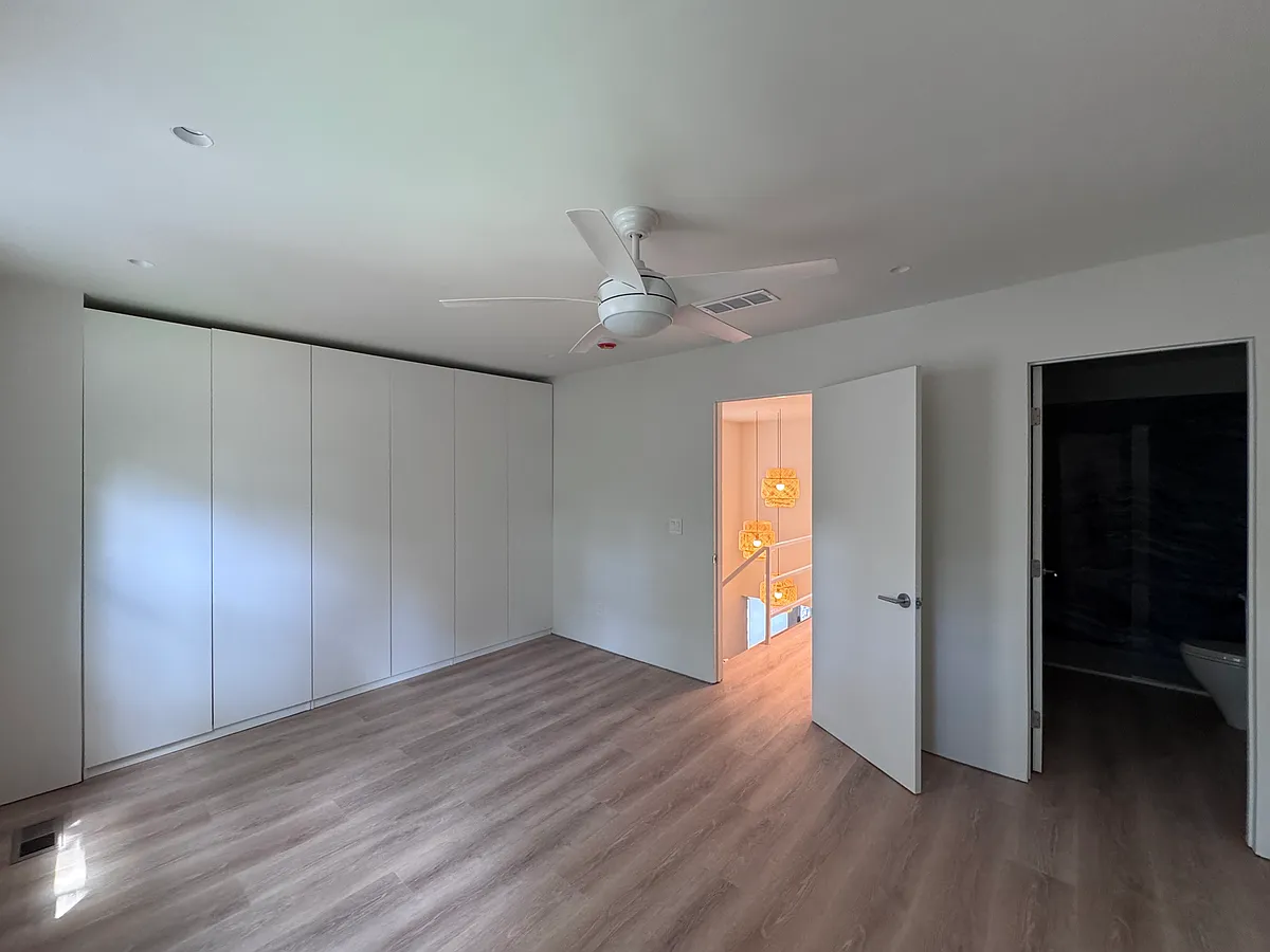 Bedroom 1 - Primary-style bedroom with floor-to-ceiling closet storage and renovated ensuite bath. - 2103 Bucktrout Pl
