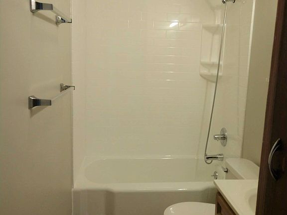Updated bathroom with a fresh white tub/shower combination.