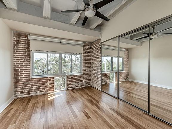 The bedroom has plenty of natural light coming in, an exposed brick wall, and inset ceilings. Plus, plenty of closet space is available for you in this welcoming bedroom!