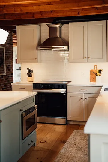 Range, vented hood, and microwave with tile backsplash