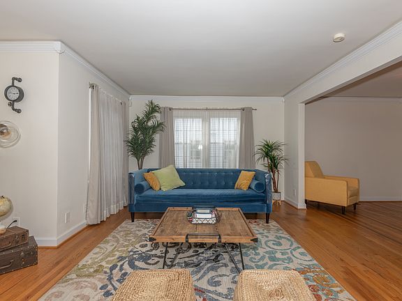 Fully furnished living room with plenty of seating. 55'' TV on adjacent wall.
