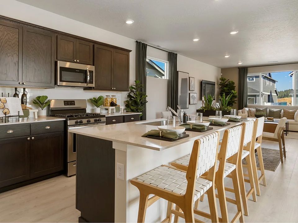Chef's Kitchen: Features a spacious prep island, premium stainless steel appliances, and a corner pantry for ample storage. Modern, stylish, and highly multifunctional. -- Model Home Images