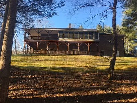 Large backyard slopes gently down to fire pit area on the banks of the Henry River.