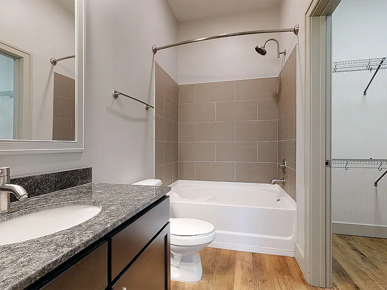 Apartment Bathroom with large soaking tub and wood-style flooring.