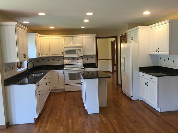 Preparing meals and entertaining is a sure delight in this kitchen - new granite countertops and tile backsplash,  newer appliances, recessed lighting and hardwood floors featured