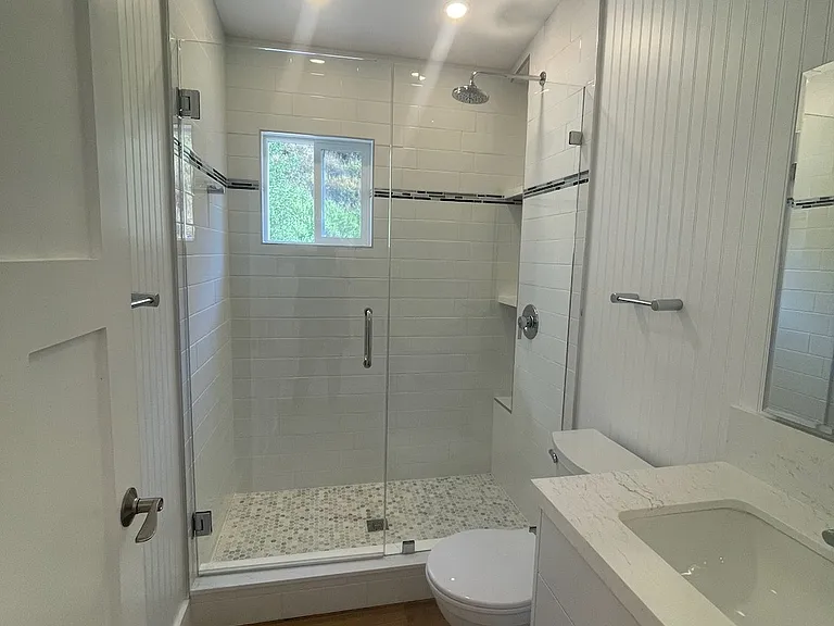 Spacious bathroom with posh fixtures, including rain shower head.