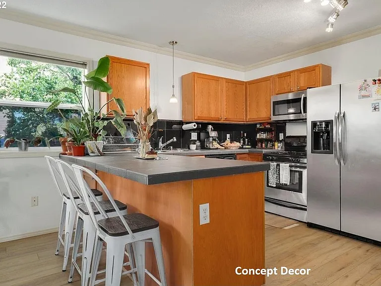 Open plan Kitchen with stainless steel gas range, microwave and fridge, showing concept decor.