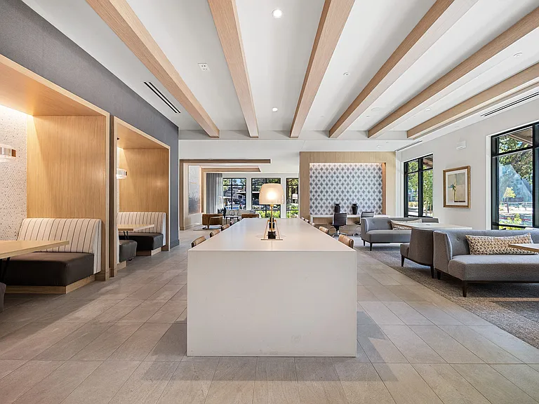 Open lounge with communal table, booths, and large windows
