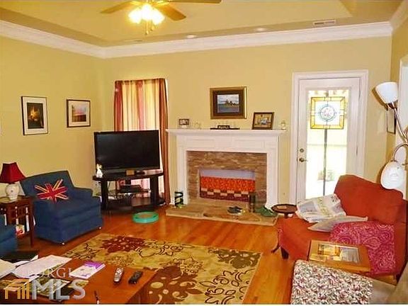 Living room with vaulted ceiling and stack-stone fireplace with gas logs
