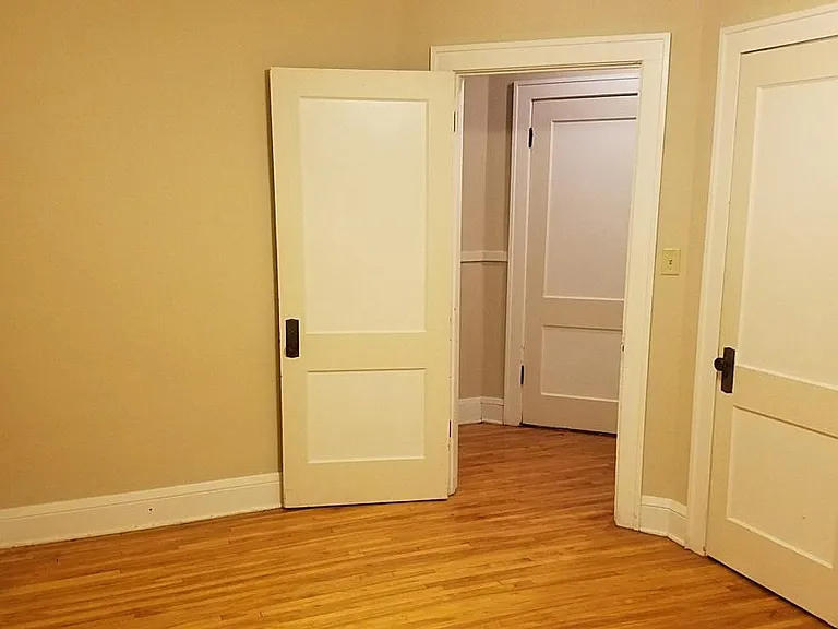 Main bedroom looking toward hallway and back door to apartment. Left is door to kitchen. Right is BR closet.