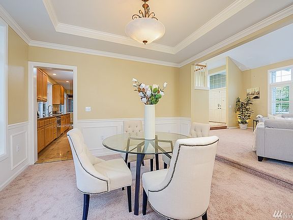 Formal dining room with recessed ceiling and wainscot walls, overlooking the Parklike backyard