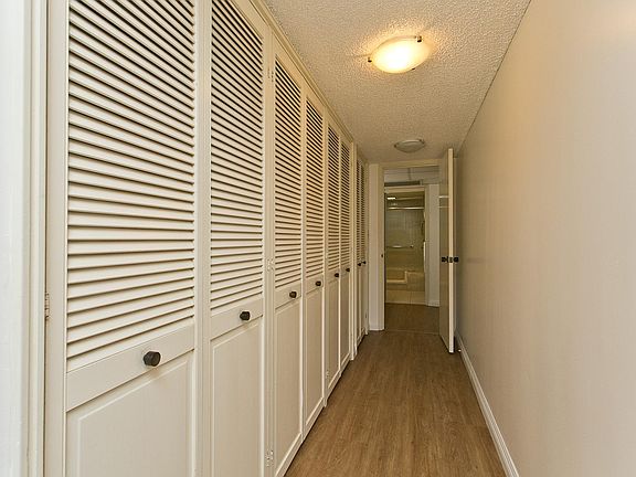 Master Bedroom closet space with ample storage and and brand new stack washer and dryer at the end of the hallway.