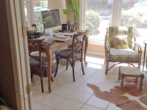 large, bright sun room with tile flooring, ceiling fan, large storm windows, custom blinds, French doors.