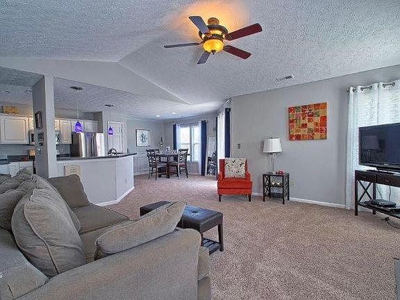 Spacious living room with vaulted ceilings, wood burning fireplace, and plenty of natural light.